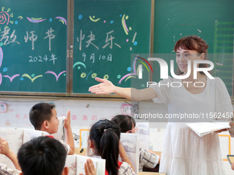 Han Jianrui, a primary school teacher, interacts with students during a ''Teachers' Day themed class meeting'' in Zaozhuang, China, on Septe...