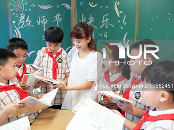 Han Jianrui, a primary school teacher, accompanies her students to read in Zaozhuang, China, on September 10, 2024. (