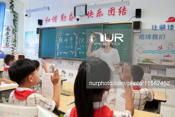 Han Jianrui, a primary school teacher, interacts with students during a ''Teachers' Day themed class meeting'' in Zaozhuang, China, on Septe...