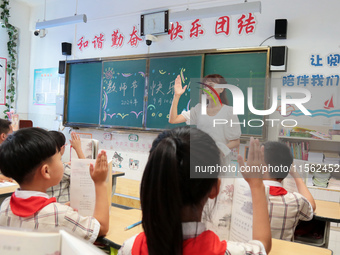 Han Jianrui, a primary school teacher, interacts with students during a ''Teachers' Day themed class meeting'' in Zaozhuang, China, on Septe...