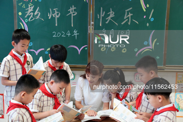 Han Jianrui, a primary school teacher, accompanies her students to read in Zaozhuang, China, on September 10, 2024. 