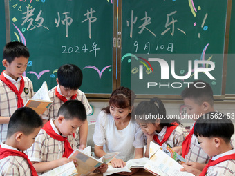 Han Jianrui, a primary school teacher, accompanies her students to read in Zaozhuang, China, on September 10, 2024. (