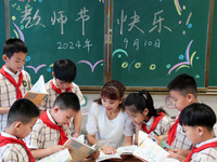 Han Jianrui, a primary school teacher, accompanies her students to read in Zaozhuang, China, on September 10, 2024. (