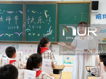 Han Jianrui, a primary school teacher, interacts with students during a ''Teachers' Day themed class meeting'' in Zaozhuang, China, on Septe...