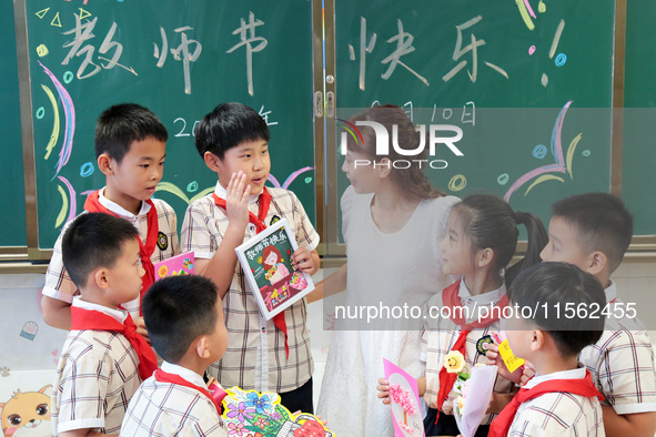 Children present handicrafts made by themselves to their teachers at Wenhua Road Primary School in Zaozhuang, China, on September 10, 2024. 