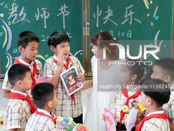 Children present handicrafts made by themselves to their teachers at Wenhua Road Primary School in Zaozhuang, China, on September 10, 2024....