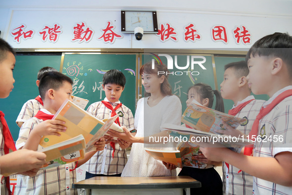 Han Jianrui, a primary school teacher, accompanies her students to read in Zaozhuang, China, on September 10, 2024. 