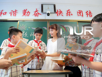 Han Jianrui, a primary school teacher, accompanies her students to read in Zaozhuang, China, on September 10, 2024. (