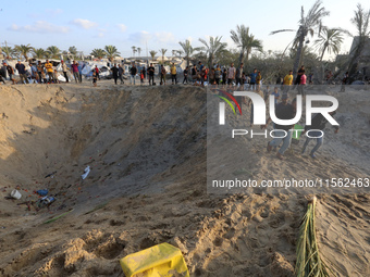 People inspect the site following Israeli strikes on a tent camp sheltering displaced people amid the Israel-Hamas conflict in the Al-Mawasi...