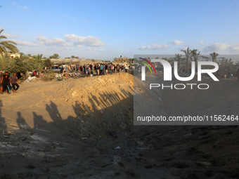 People inspect the site following Israeli strikes on a tent camp sheltering displaced people amid the Israel-Hamas conflict in the Al-Mawasi...