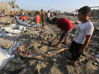 People inspect the site following Israeli strikes on a tent camp sheltering displaced people amid the Israel-Hamas conflict in the Al-Mawasi...