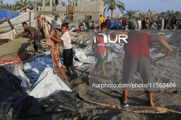 People inspect the site following Israeli strikes on a tent camp sheltering displaced people amid the Israel-Hamas conflict in the Al-Mawasi...