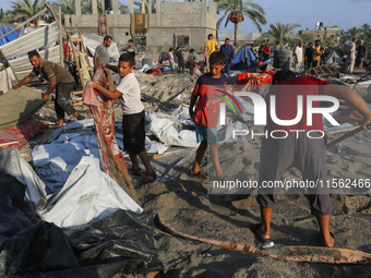 People inspect the site following Israeli strikes on a tent camp sheltering displaced people amid the Israel-Hamas conflict in the Al-Mawasi...