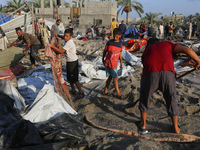 People inspect the site following Israeli strikes on a tent camp sheltering displaced people amid the Israel-Hamas conflict in the Al-Mawasi...