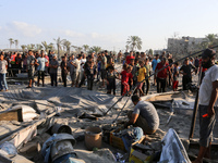 People inspect the site following Israeli strikes on a tent camp sheltering displaced people amid the Israel-Hamas conflict in the Al-Mawasi...