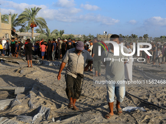 People inspect the site following Israeli strikes on a tent camp sheltering displaced people amid the Israel-Hamas conflict in the Al-Mawasi...