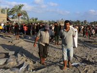 People inspect the site following Israeli strikes on a tent camp sheltering displaced people amid the Israel-Hamas conflict in the Al-Mawasi...