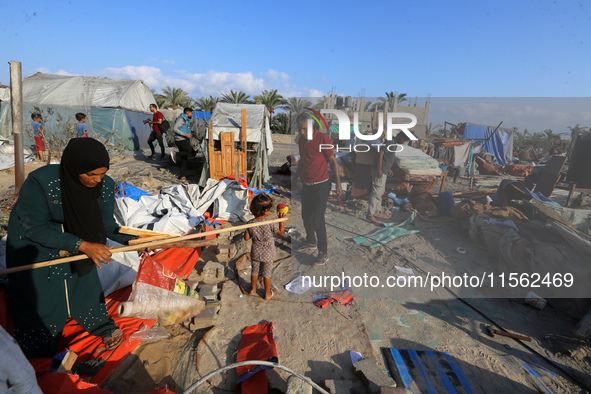 People inspect the site following Israeli strikes on a tent camp sheltering displaced people amid the Israel-Hamas conflict in the Al-Mawasi...