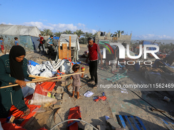 People inspect the site following Israeli strikes on a tent camp sheltering displaced people amid the Israel-Hamas conflict in the Al-Mawasi...