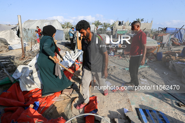 People inspect the site following Israeli strikes on a tent camp sheltering displaced people amid the Israel-Hamas conflict in the Al-Mawasi...