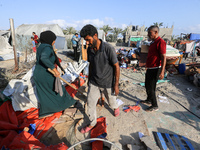 People inspect the site following Israeli strikes on a tent camp sheltering displaced people amid the Israel-Hamas conflict in the Al-Mawasi...