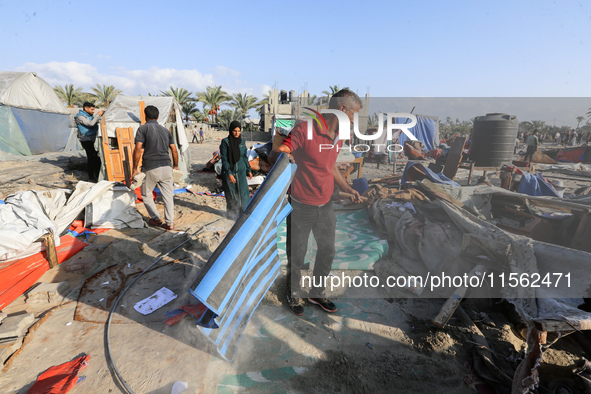 People inspect the site following Israeli strikes on a tent camp sheltering displaced people amid the Israel-Hamas conflict in the Al-Mawasi...