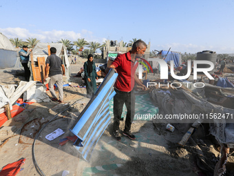 People inspect the site following Israeli strikes on a tent camp sheltering displaced people amid the Israel-Hamas conflict in the Al-Mawasi...