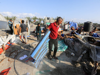 People inspect the site following Israeli strikes on a tent camp sheltering displaced people amid the Israel-Hamas conflict in the Al-Mawasi...