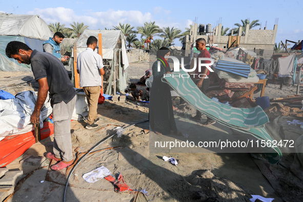 People inspect the site following Israeli strikes on a tent camp sheltering displaced people amid the Israel-Hamas conflict in the Al-Mawasi...