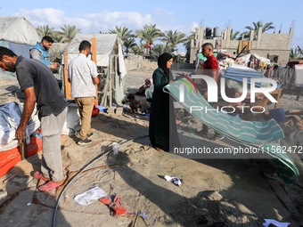 People inspect the site following Israeli strikes on a tent camp sheltering displaced people amid the Israel-Hamas conflict in the Al-Mawasi...