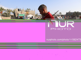 People inspect the site following Israeli strikes on a tent camp sheltering displaced people amid the Israel-Hamas conflict in the Al-Mawasi...