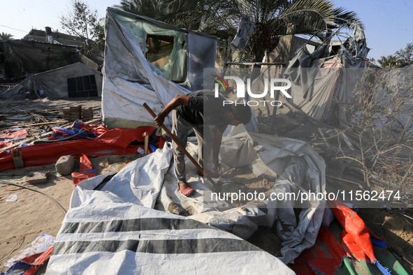 People inspect the site following Israeli strikes on a tent camp sheltering displaced people amid the Israel-Hamas conflict in the Al-Mawasi...