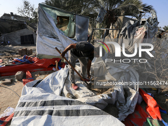 People inspect the site following Israeli strikes on a tent camp sheltering displaced people amid the Israel-Hamas conflict in the Al-Mawasi...