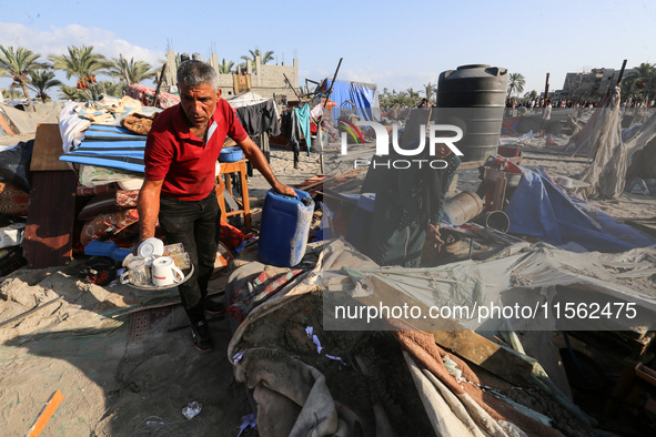 People inspect the site following Israeli strikes on a tent camp sheltering displaced people amid the Israel-Hamas conflict in the Al-Mawasi...