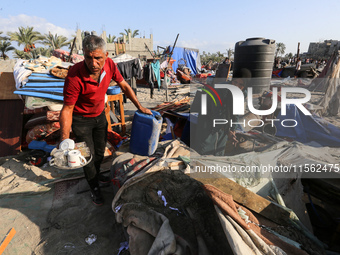 People inspect the site following Israeli strikes on a tent camp sheltering displaced people amid the Israel-Hamas conflict in the Al-Mawasi...