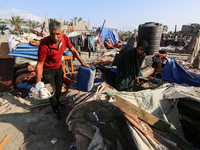 People inspect the site following Israeli strikes on a tent camp sheltering displaced people amid the Israel-Hamas conflict in the Al-Mawasi...