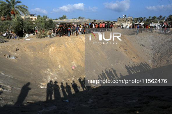 People inspect the site following Israeli strikes on a tent camp sheltering displaced people amid the Israel-Hamas conflict in the Al-Mawasi...