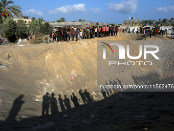 People inspect the site following Israeli strikes on a tent camp sheltering displaced people amid the Israel-Hamas conflict in the Al-Mawasi...