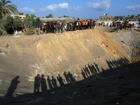 People inspect the site following Israeli strikes on a tent camp sheltering displaced people amid the Israel-Hamas conflict in the Al-Mawasi...