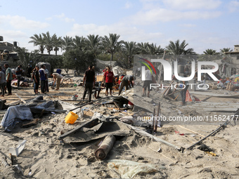 People inspect the site following Israeli strikes on a tent camp sheltering displaced people amid the Israel-Hamas conflict in the Al-Mawasi...