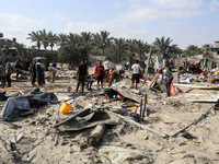 People inspect the site following Israeli strikes on a tent camp sheltering displaced people amid the Israel-Hamas conflict in the Al-Mawasi...