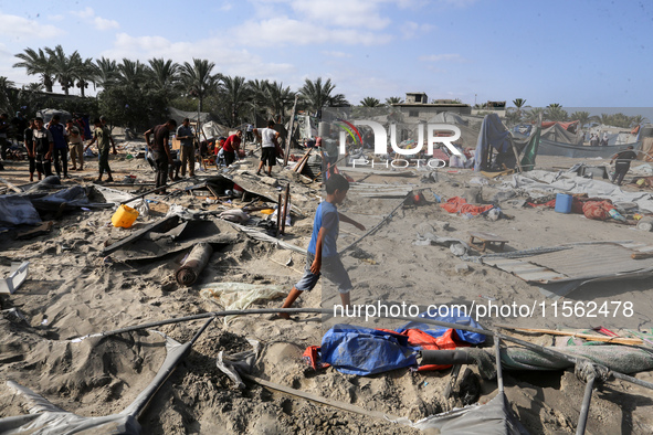 People inspect the site following Israeli strikes on a tent camp sheltering displaced people amid the Israel-Hamas conflict in the Al-Mawasi...