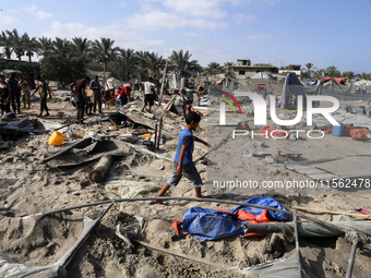 People inspect the site following Israeli strikes on a tent camp sheltering displaced people amid the Israel-Hamas conflict in the Al-Mawasi...