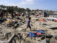 People inspect the site following Israeli strikes on a tent camp sheltering displaced people amid the Israel-Hamas conflict in the Al-Mawasi...