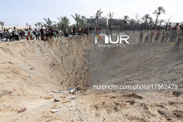 People inspect the site following Israeli strikes on a tent camp sheltering displaced people amid the Israel-Hamas conflict in the Al-Mawasi...