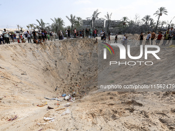 People inspect the site following Israeli strikes on a tent camp sheltering displaced people amid the Israel-Hamas conflict in the Al-Mawasi...