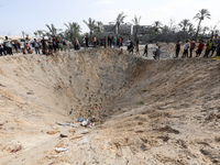 People inspect the site following Israeli strikes on a tent camp sheltering displaced people amid the Israel-Hamas conflict in the Al-Mawasi...