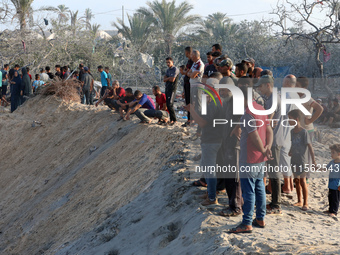 People inspect the site following Israeli strikes on a tent camp sheltering displaced people amid the Israel-Hamas conflict in the Al-Mawasi...