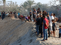 People inspect the site following Israeli strikes on a tent camp sheltering displaced people amid the Israel-Hamas conflict in the Al-Mawasi...