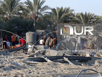 People inspect the site following Israeli strikes on a tent camp sheltering displaced people amid the Israel-Hamas conflict in the Al-Mawasi...